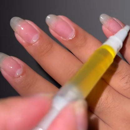 Hand holding a small bottle with a yellow liquid against a dark background