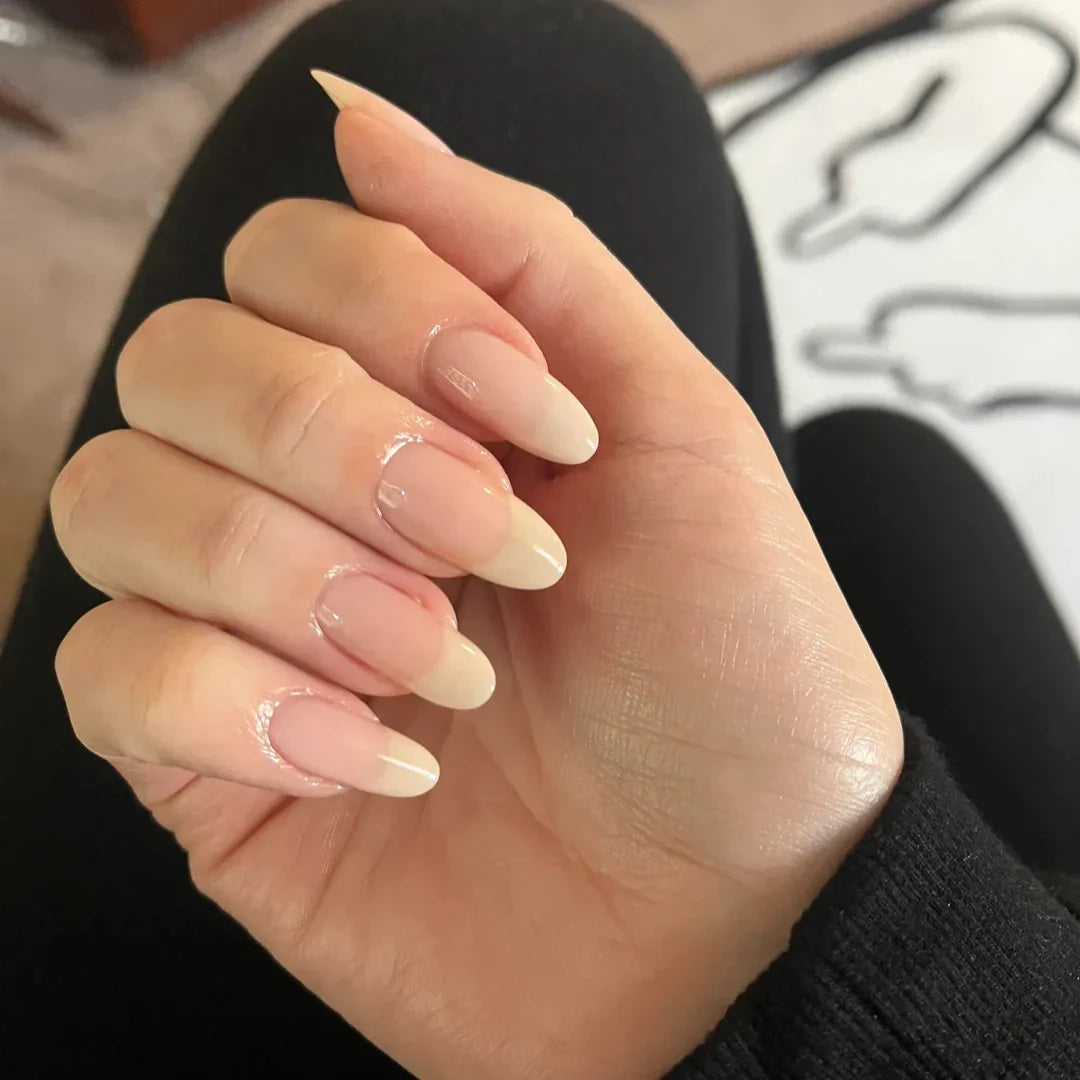 Hand with beige nail polish on a blurred background